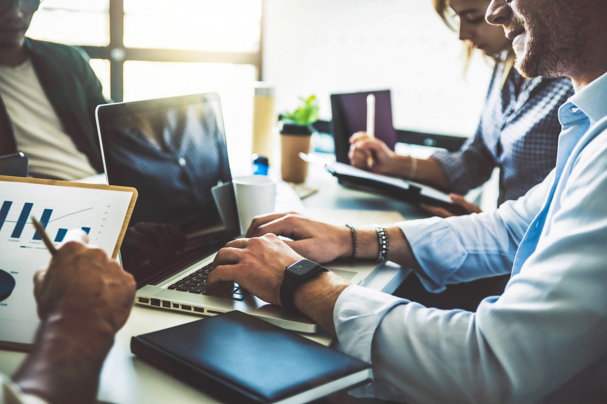 Group of business people working with computer and communicating sitting at office desk